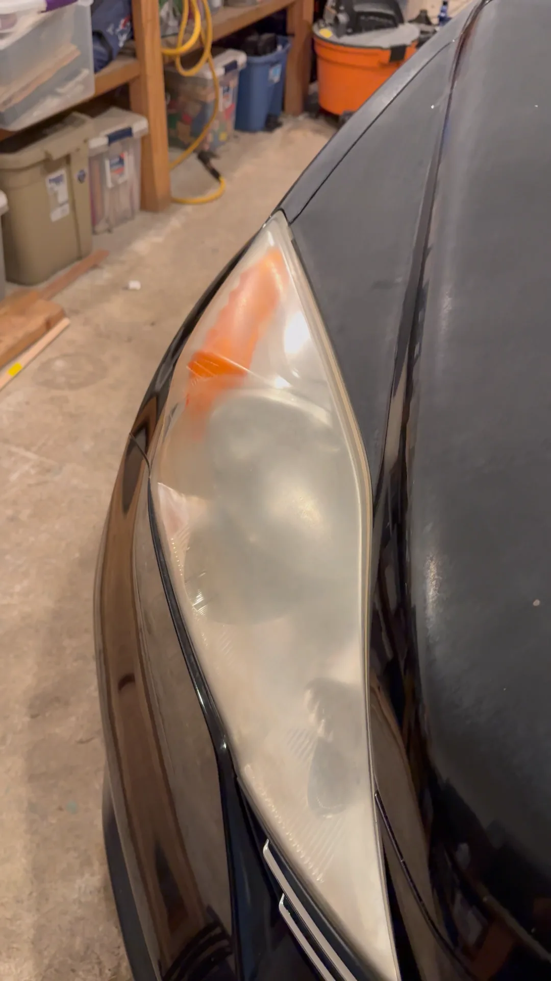 Before: a yellowed, foggy headlight on a black car