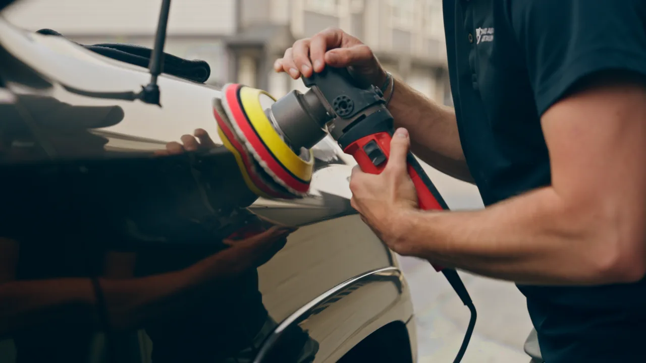 Machine polishing the paint on an SUV fender